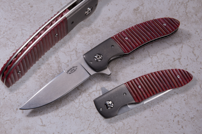 The "Vanguard ll" Flipper, fitted with a 3 1/2" CPM-154 SS stone washed blade, stone washed titanium bolsters, and fitted with fluted red Linen Micarta scales, and fileworked red Linen Micarta backspacer.