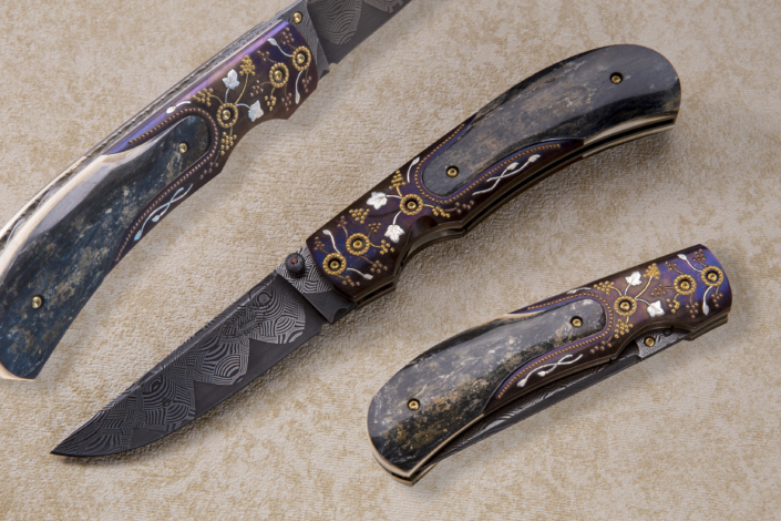 SOLD - The "Zenith", Fitted with Presentation grade Blue/Green Mammoth ivory scales, engraved mild steel bolsters, with gold, silver & copper, by Joe Mason, and a 3 inch "Basket Weave" Damascus blade by Bruce Bump. Click on image to view in high resolution.